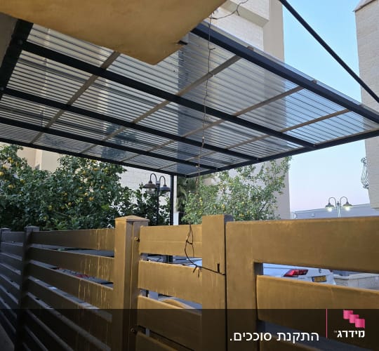 סוכך מתכת וזכוכית מעל גדר חיצונית